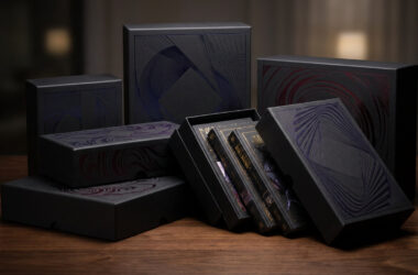 Ensemble de boîtes collector noires et élégantes pour la série manga Jujutsu Kaisen sur une table en bois.