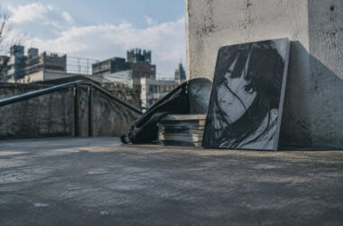 Artbook Ctrl+T2 d'Inio Asano posé sur un rebord en béton avec une ville en arrière-plan sous un ciel bleu.
